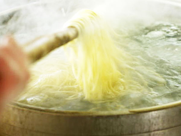 大鍋で麺をゆで上げる。
